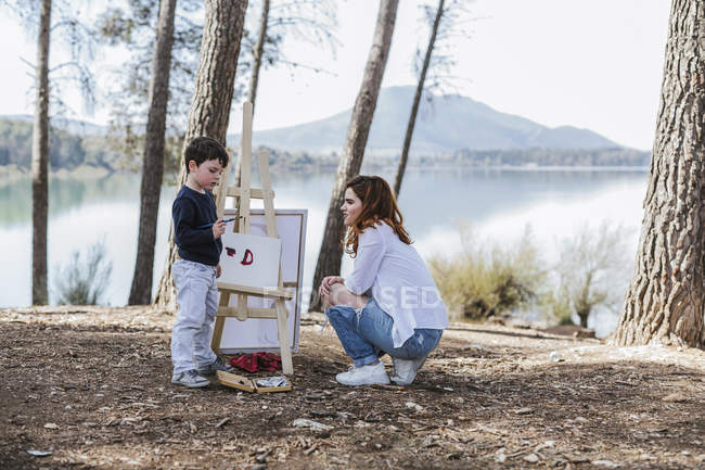 Peinture de mère et garçon près du lac — Photo de stock