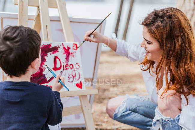 Peinture de mère et garçon près du lac — Photo de stock