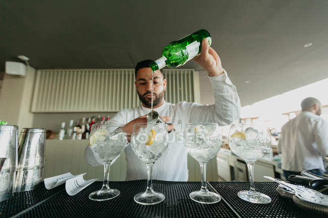Camarero preparando bebidas alcohólicas en el bar - foto de stock