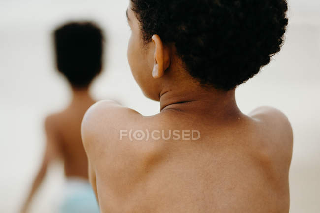 Vue arrière du garçon afro-américain passant du temps sur la plage — Photo de stock