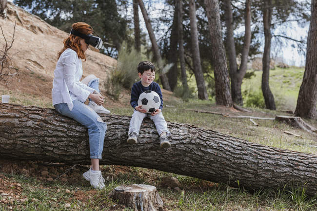 Niño mirando a la madre en los auriculares VR - foto de stock