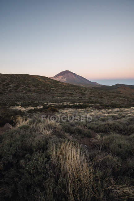 Mountain peak in desert valley at sunset — Stock Photo