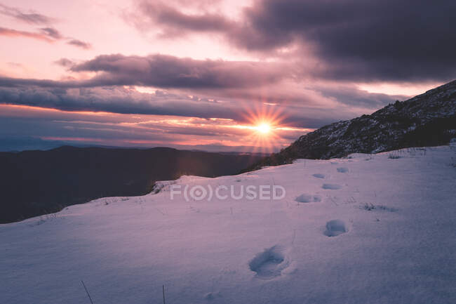 Sun setting over snowy mountains — Stock Photo