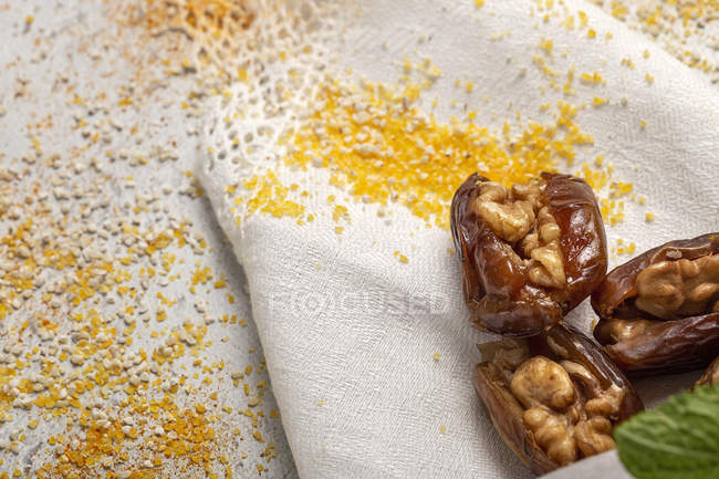 Халяльные закуски для Рамадана с сушеными финиками и грецкими орехами на белой ткани — стоковое фото