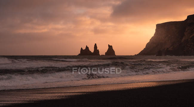 Playa y formaciones rocosas al atardecer en Islandia Vik Sand Beach - foto de stock