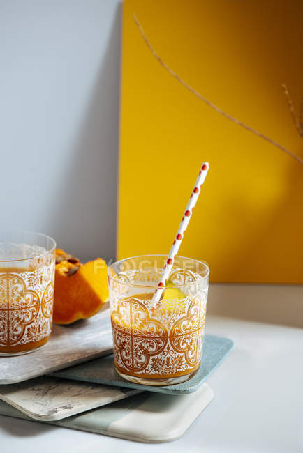 Mangue et citrouille verres à smoothie sur des planches empilées — Photo de stock