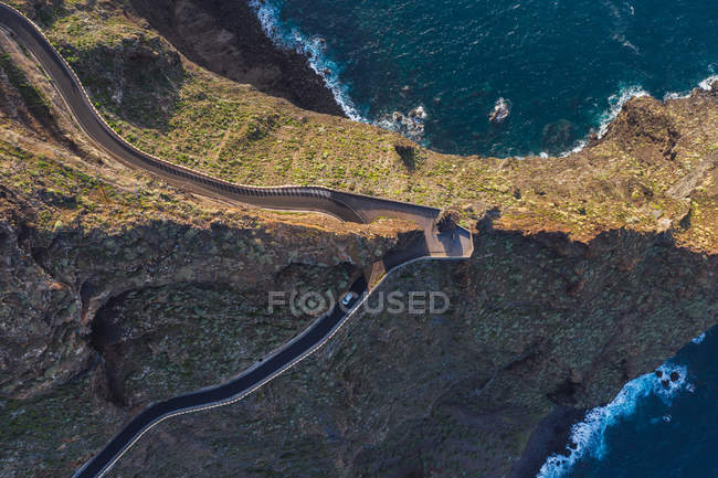 Camino curvo a través del paisaje desértico y la costa marina - foto de stock