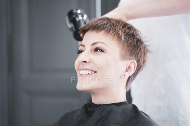 Hairdresser drying hair to woman — Stock Photo