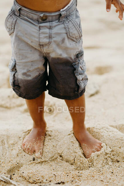 Lustiger afroamerikanischer Junge mit Spielen am Sandstrand in der Nähe des Meeres — Stockfoto