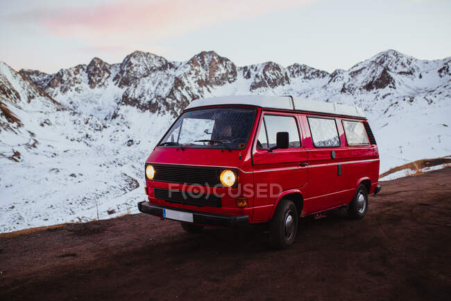 Красный караван рядом со снежными горами — стоковое фото