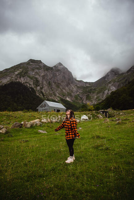 Fröhliche junge Frau steht in Berg — Stockfoto