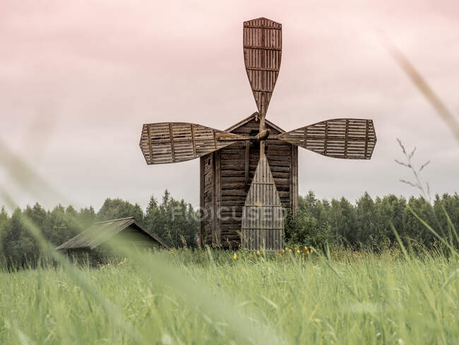 Engajando velho moinho de vento de madeira na fronteira de campo e floresta na Finlândia — Fotografia de Stock