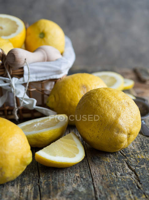 Свіжі лимони та дерев'яний скрип на дерев'яній дошці — стокове фото