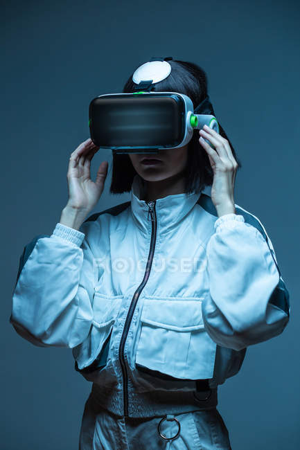 Возбужденная девушка, имеющая опыт виртуальной реальности в неоновом свете — стоковое фото