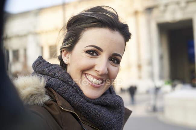 Jovem mulher alegre em roupas de inverno tirar uma selfie com telefone inteligente ao ar livre em Milão Itália — Fotografia de Stock