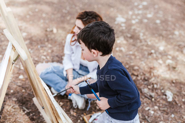 Мати і хлопчик малюють біля озера — стокове фото