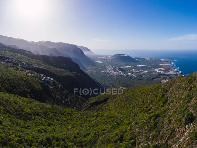 Vista aérea de la ciudad y la costa desde la cima de la montaña en España con iluminación de luz solar brillante - foto de stock