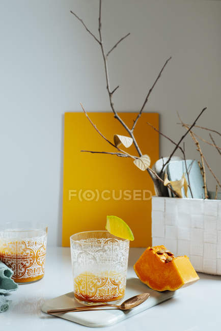 Vasos de licuado de mango y calabaza sobre fondo blanco - foto de stock