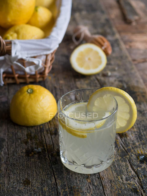 Verre de délicieuse boisson fraîche au citron maison sur une table en bois — Photo de stock