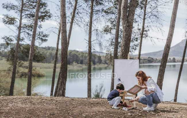 Mutter und Junge malen am See — Stockfoto