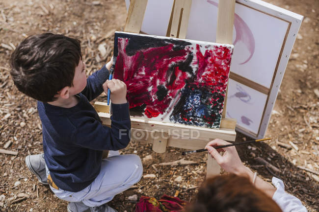 Mãe e menino pintura perto do lago — Fotografia de Stock