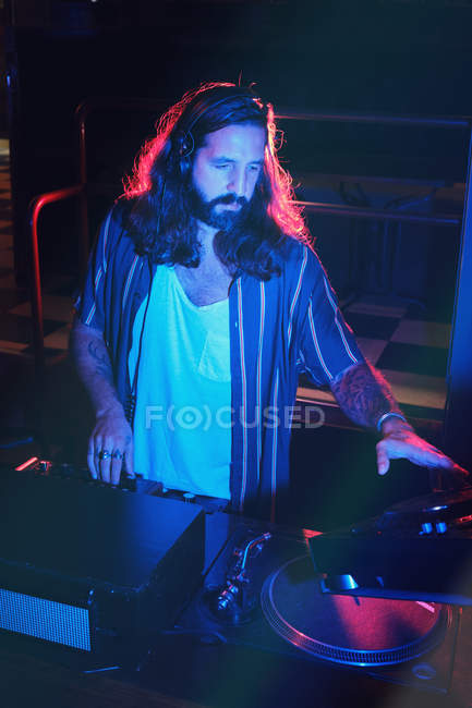 Barbudo dj hombre jugando disco música en un club - foto de stock