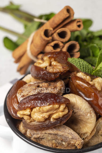 Nahaufnahme von getrockneten Datteln, Feigen, frischer Minze und Zimt als Halal-Snack für Ramadan im Topf — Stockfoto