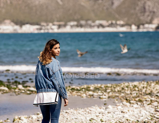 Молодая женщина идет по берегу моря — стоковое фото