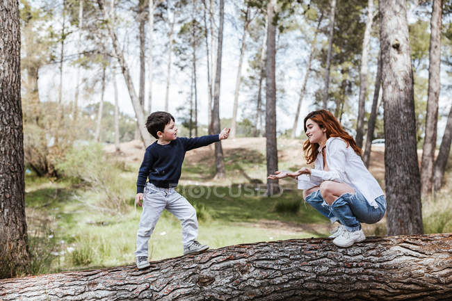 Madre joven comunicándose con el hijo en la naturaleza - foto de stock