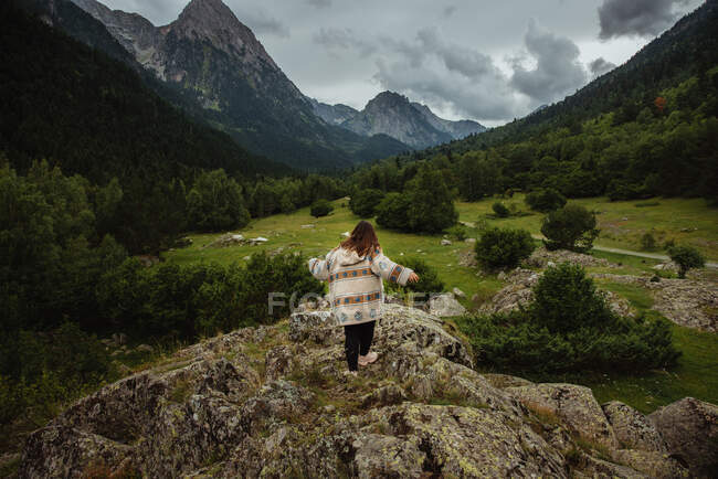Mujer anónima en colina pedregosa - foto de stock