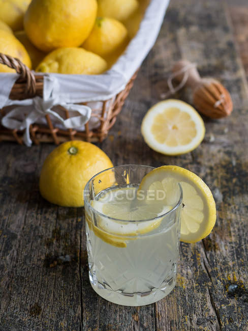 Bicchiere di deliziosa bevanda al limone fresca fatta in casa sul tavolo di legno — Foto stock
