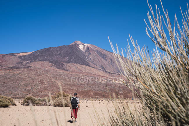 Man walking to mountain peak in Spanish desert — Stock Photo