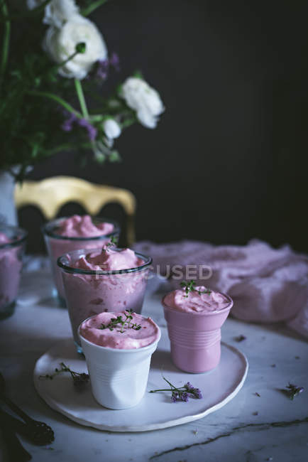 Склянки солодкого полуничного мусу на столі з квітами — стокове фото