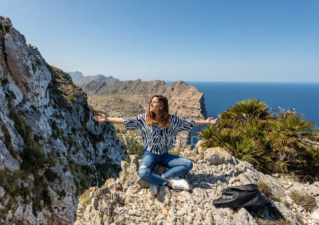 Молодая женщина сидит на скале — стоковое фото