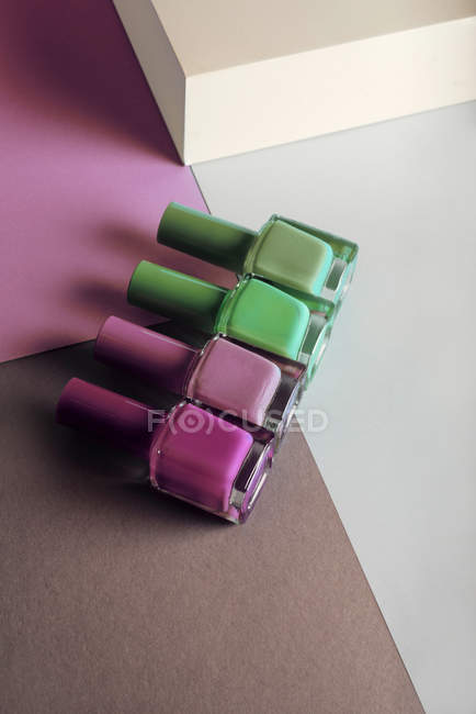 Різнокольорові лаки для нігтів на геометричному тлі кольорів — стокове фото