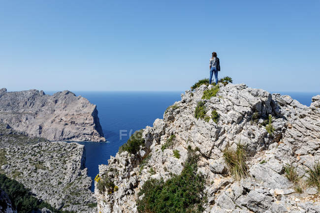 Young woman standing on cliff — Stock Photo