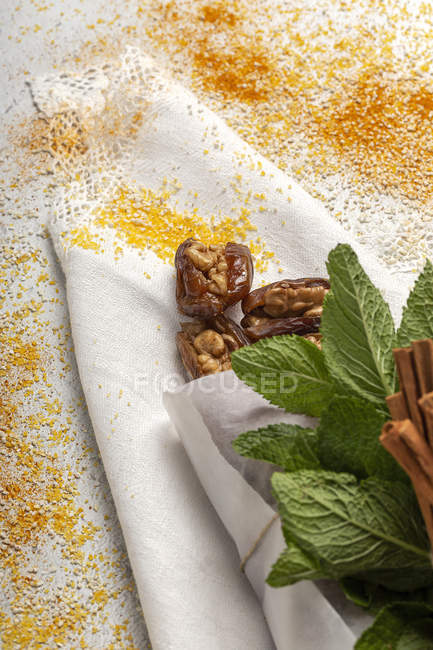 Merenda halal per Ramadan con datteri secchi, fichi, menta fresca e cannella su panno bianco — Foto stock