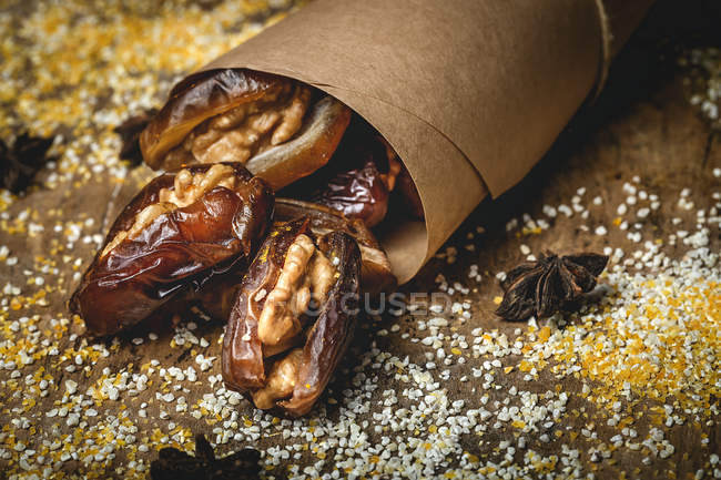 Halal snack for Ramadan with dried dates, figs and cinnamon wrapped in parchment — Stock Photo