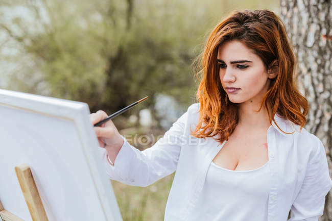 Молодая женщина рисует в сельской местности — стоковое фото
