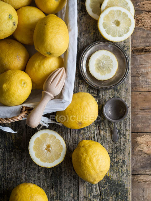 Frische Zitronen und Holzpresse auf Holzbrett — Stockfoto