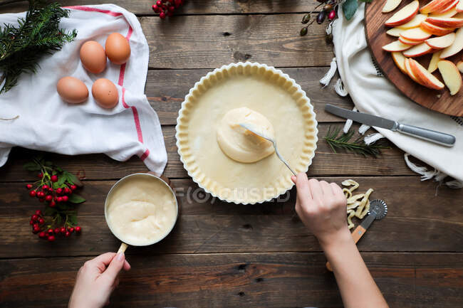 Unerkennbare Frau backt Apfelkuchen auf Holztisch — Stockfoto