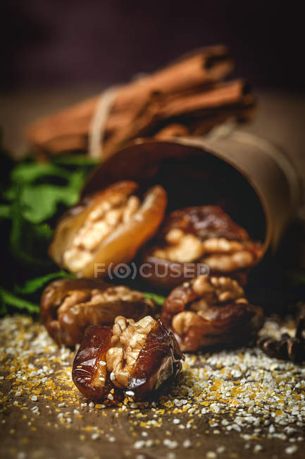 Snack halal para Ramadán con dátiles secos, higos, menta fresca y canela envuelta en pergamino - foto de stock