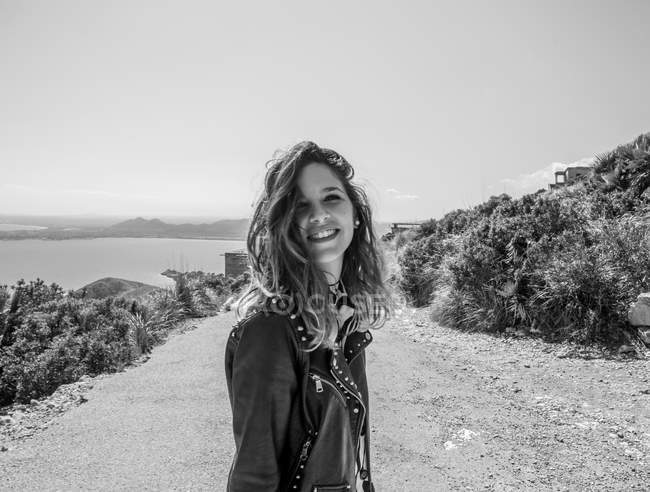 Donna sorridente in riva al mare — Foto stock
