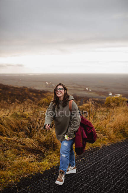 Mujer caminando en la ladera en un día sombrío - foto de stock