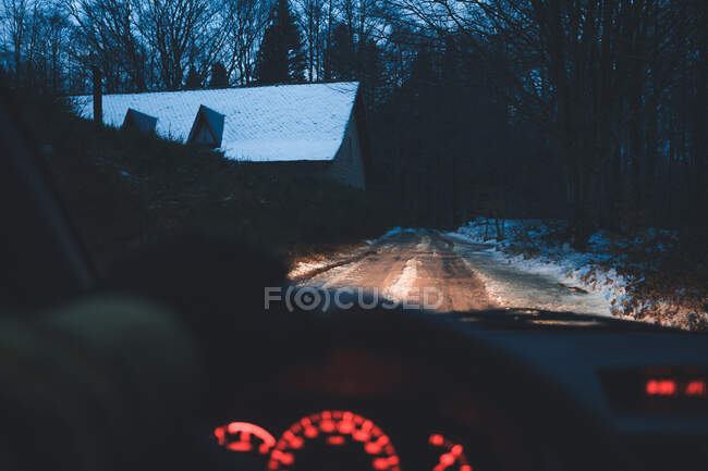 Crop hand driving car in winter village — Stock Photo