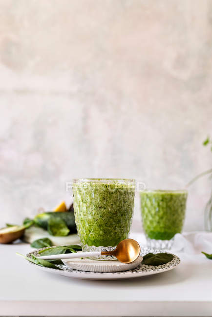 Frullato verde sano di spinaci, avocado e kiwi, mela e limone in vetro su piatto fantasia — Foto stock