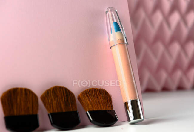 Lápices cosméticos:, maquillaje lápiz delineador de ojos azul, fondo moderno con relieves de color rosa chevron. inventar el concepto - foto de stock