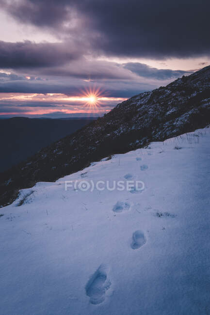 Sole che tramonta sulle montagne innevate — Foto stock