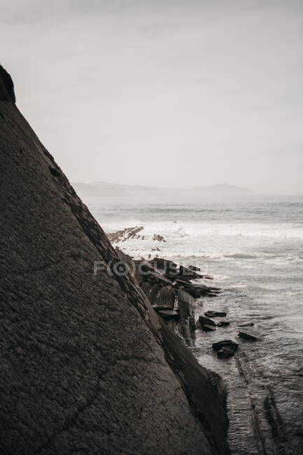 Скала возле бурного моря — стоковое фото