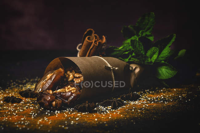 Nahaufnahme von Halal-Snack für Ramadan mit getrockneten Datteln und in Pergament eingewickelten Walnüssen — Stockfoto